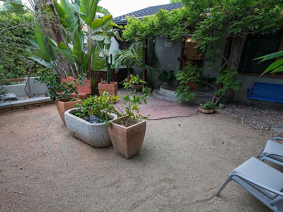 Main house enclosed and private front yard featuring a porch swing and granite horse trough pond