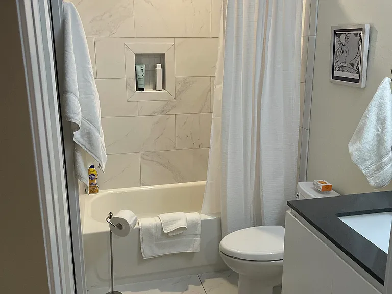 Bathroom featuring simulated marble shower walls & flooring