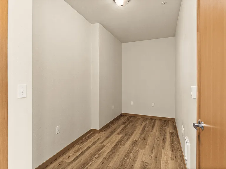 Inviting den with elegant wood flooring and soft neutral walls, perfect for a cozy office or guest space. Inviting den with elegant wood flooring and soft neutral walls, perfect for a cozy office or guest space.