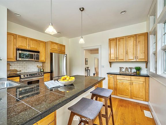 Spacious eat-in kitchen with breakfast bar, granite island and stainless steel appliances.