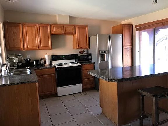 Kitchen with peninsula of cabinets for all the chef's accoutrements and seating on the near side.