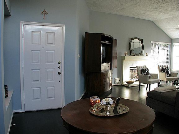 Large entry foyer is open to the living room. Dark laminate wood flooring covers the living areas.