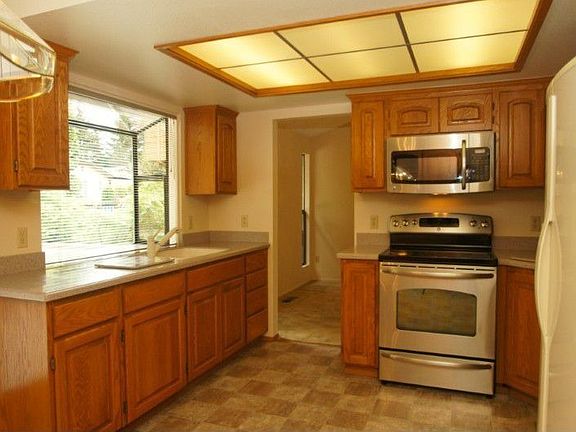 Remodeled kitchen features raised panel oak cabinets with pull-out shelves, Corian counter tops, garden window, stainless steel appliances.