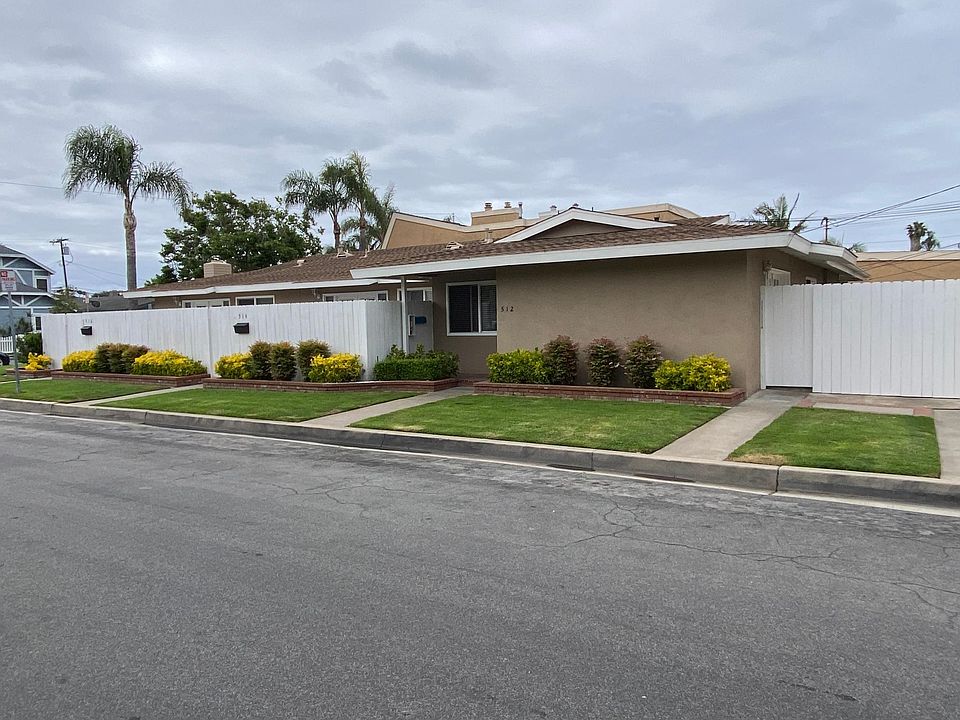 Two additional units behind the white fence. Yard space is behind the fence on the right.