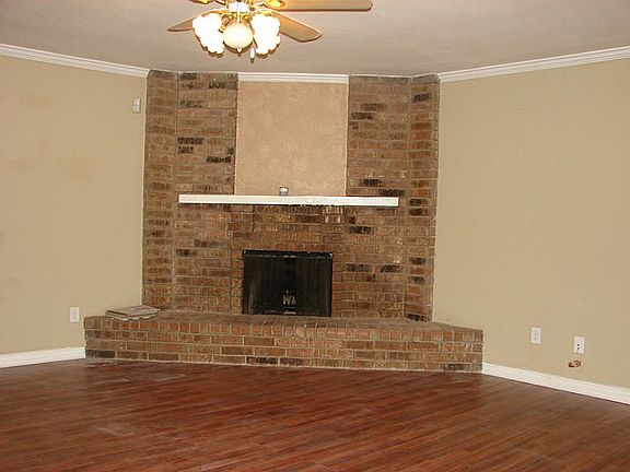 Corner brick fireplace compliments the den