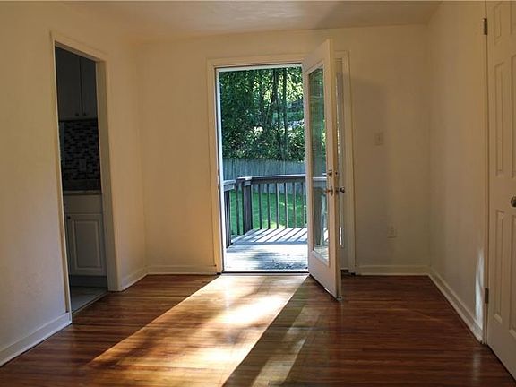 The dining room as seen from the living room. The room is filled with afternoon light from the patio door.