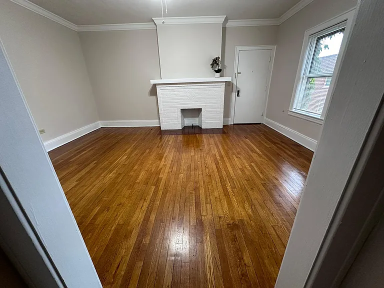 Living room with decorative fireplace and original crown moldings. Overlooks Courtyard