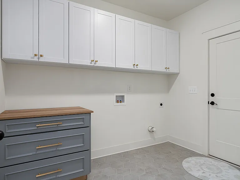 Mudroom serves as a second purpose to the large laundry room entering from the garage. Upgraded with Closet Pro upper cabinets custom Schuler folding table with 3 large drawers.