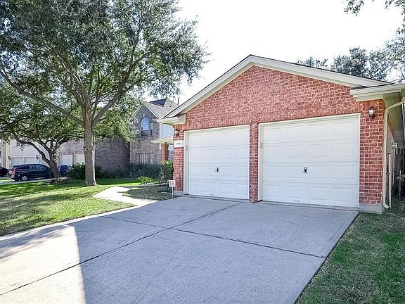 Here's a view of the pristine, paved double-wide driveway and dual-car garage. Note the wooden fence, right, to ensure greater privacy.