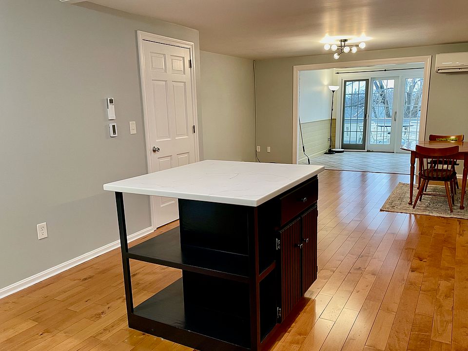 View of living/dining area from kitchen with sunroom in back