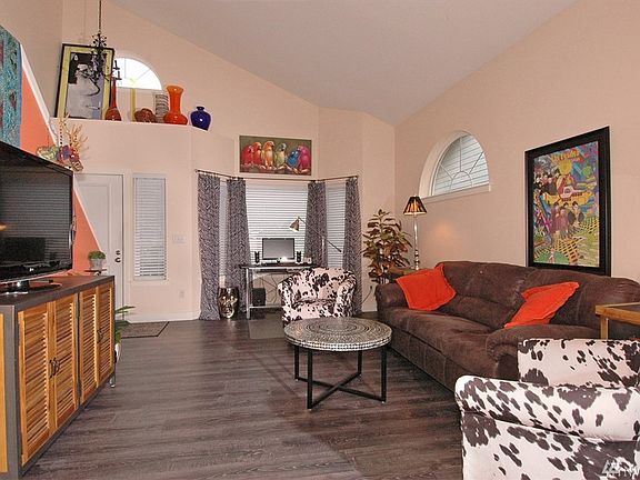 Another view of the living room with laminate floors, vaulted ceilings and lots of natural light.