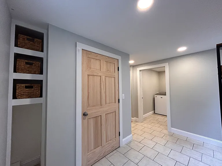 Mudroom with coat closet and storage nook.