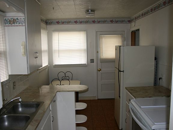 View of kitchen furnished with table and chairs. Window ove