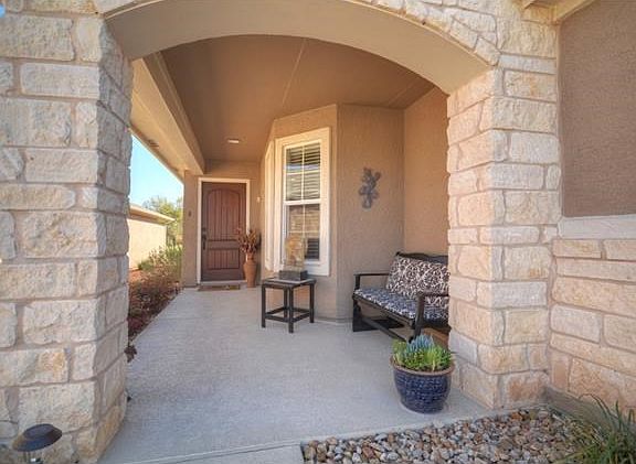 An arched Front Sitting Porch is a perfect place for friends to park the umbrellas on a rainy day.
