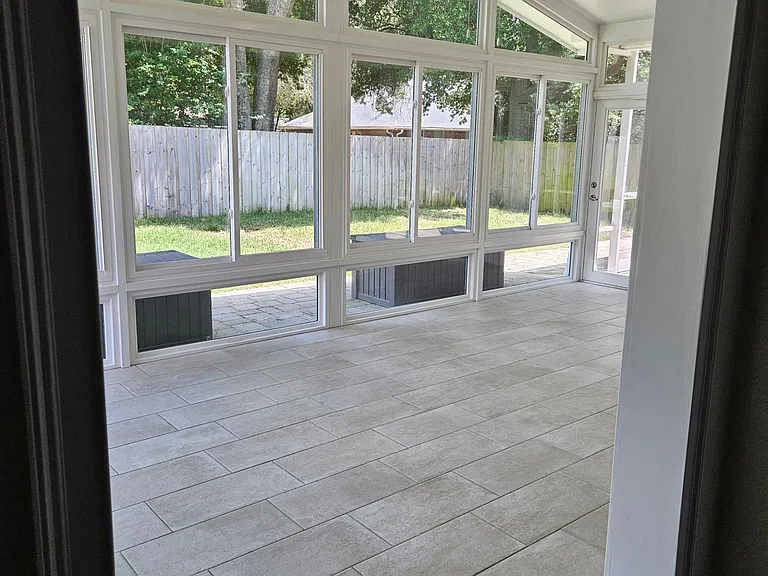 Entrance to Sunroom. Porcelain tiled, ceiling fan with light, and entrances directly to the screened room to the right, or the backyard to the left.