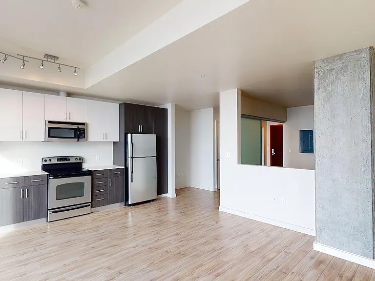 Apartment dining and living room with wood-style flooring.