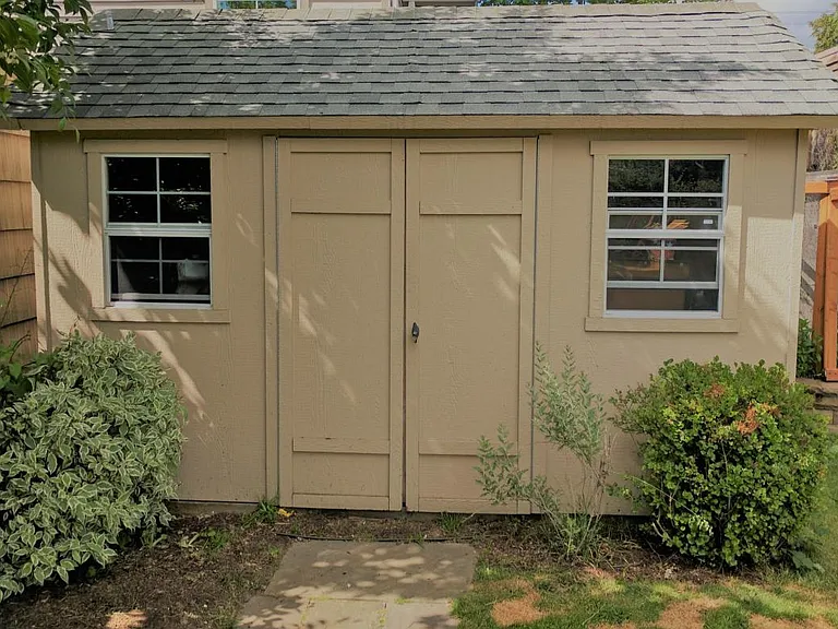 Shed, with second refrigerator and yard equipment.
