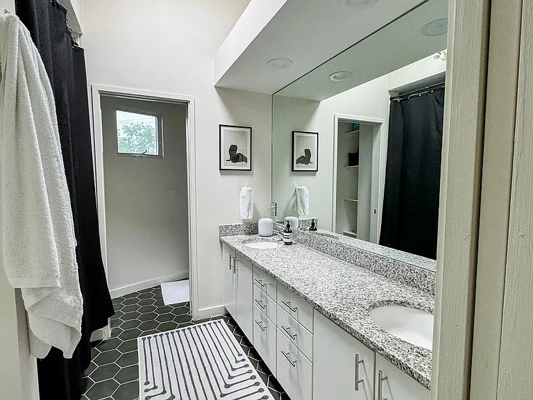 Master bathroom with dual sinks and skylight