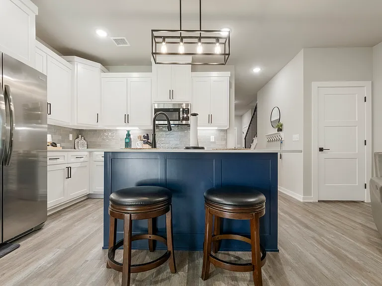 Kitchen island includes bar stools for adding seating or a quick bite