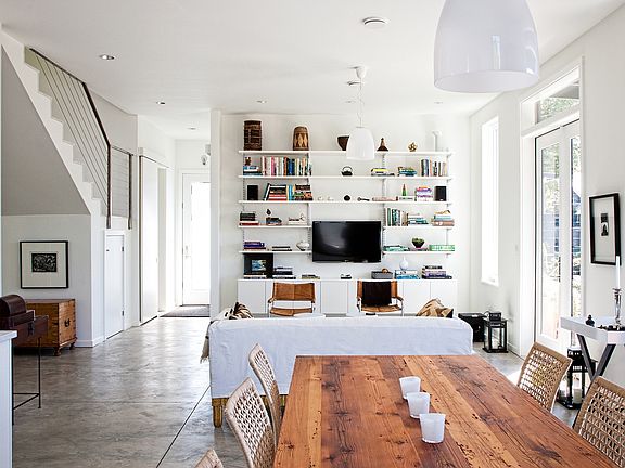 Open plan dining and living room with French doors to covered concrete patio