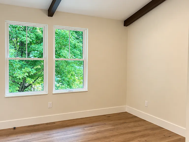 Bright and inviting second bedroom features vaulted ceilings, and an airy open feel filled with natural light.