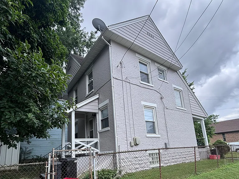 Side elevation of the duplex. Unit 1 is on the first floor and features a private entrance - small porch on the left.