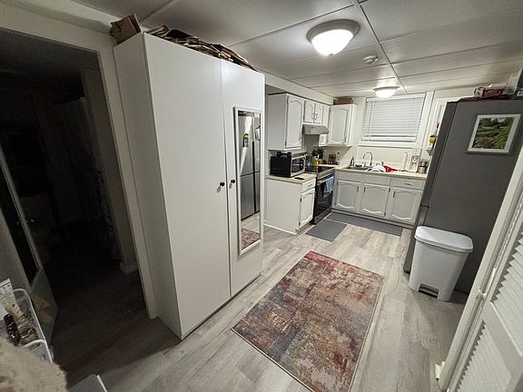 Kitchen. All new appliances. That is a window above sink. Huge storage armoire to left. To left of white armoire, is bathroom.