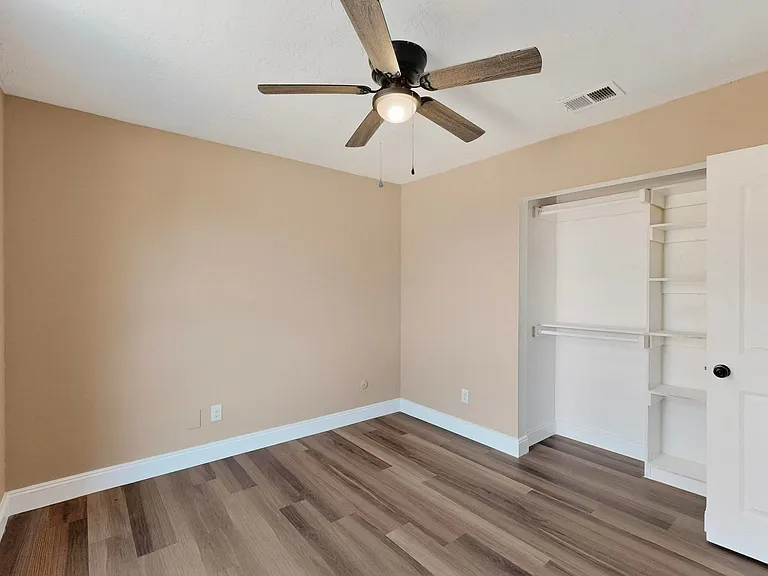 Unfurnished bedroom featuring light wood-type flooring, a closet, and ceiling fan