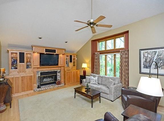 The living room on the main level offers custom built in cabinets and large windows for natural light.