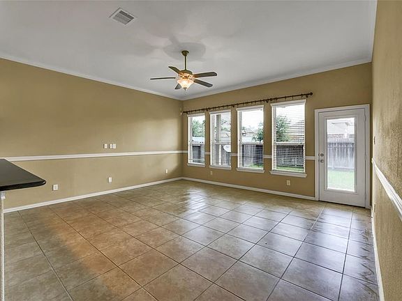 Spacious Family Room with wall of windows and door leading to Covered Patio.  Beautiful Tile Flooring and fresh paint. Clean as a whistle and ready for you to make it your own.