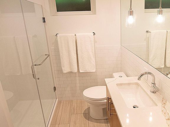 Bathroom includes a custom walk-in shower & new vanity with plenty of storage.