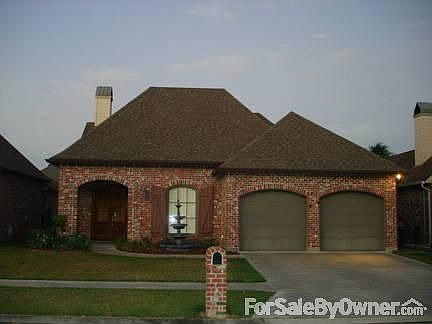 Front of Home : 2 car garage with wall shelving unit, floored portion of attic