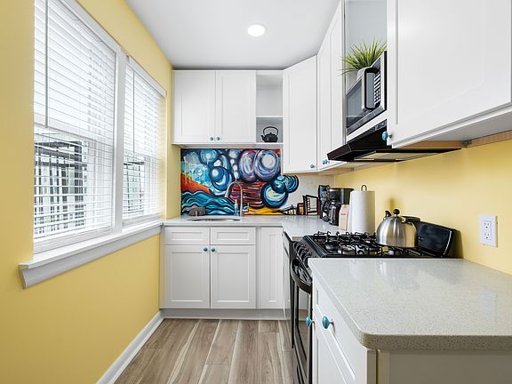 Kitchen includes a sink with garbage disposal, dishwasher, range, microwave, and refrigerator/freezer with ice maker.