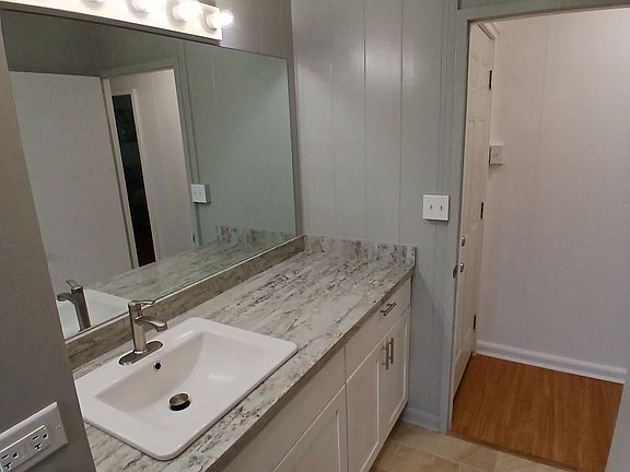 Newer bathroom cabinet with quartz countertop.