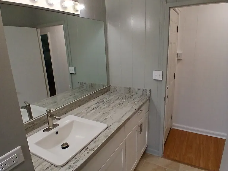 Newer bathroom cabinet with quartz countertop.