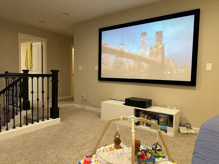 Loft with a 100 inch projector screen with built-in 5.1 speaker systems in the wall
