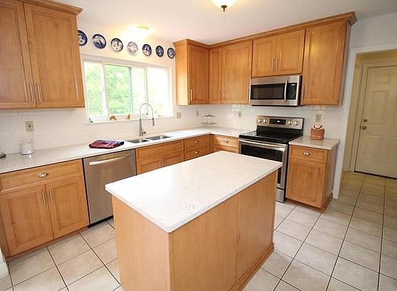 Newly updated Kitchen with new tile stone counter tops, subway tile back splash, stainless steel double sink and appliances.  Large sliding windows overlook the beautiful level back yard.  Gorgeous!