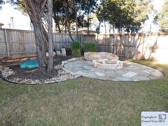 TREED BACK YARD WITH FIRE PIT