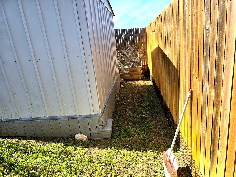 Backyard includes storage shed and open space; ideal for extra storage.