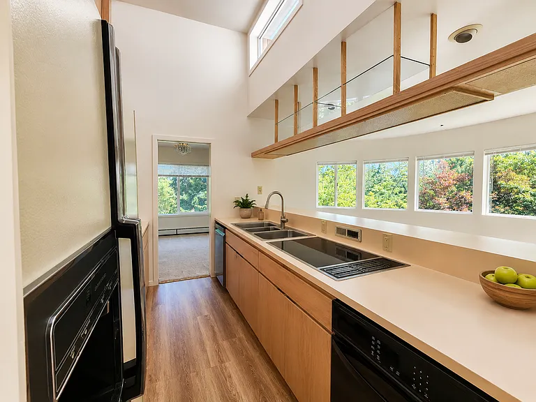 View of the spacious kitchen from the entry with the living room to the right and the dining room at the end.