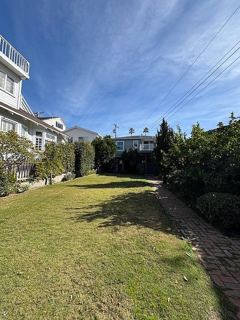 huge yard, the lower level of that grey house at the end is the apartment for rent.