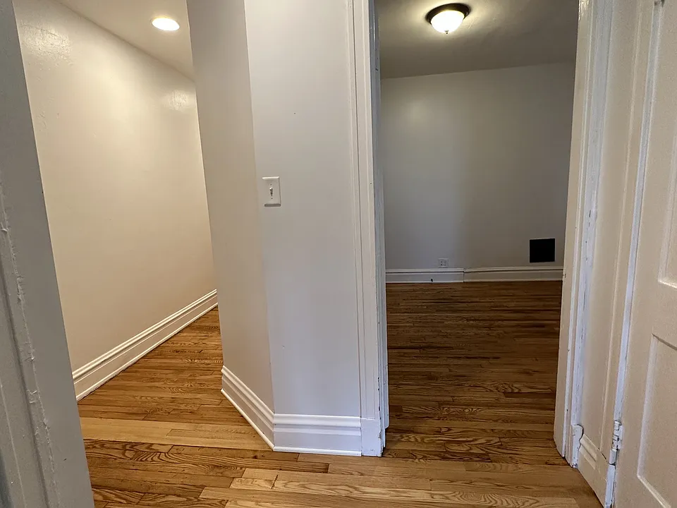 private bedroom just off of the bathroom, linen closet on the right, wood floors, well illuminated.