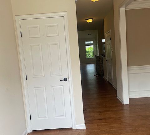 Coat closet within large foyer area with cathedral ceiling.