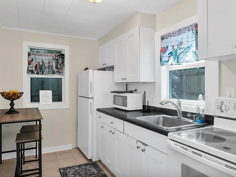 Windowed kitchen (windows on three sides) and additional work or dining space.