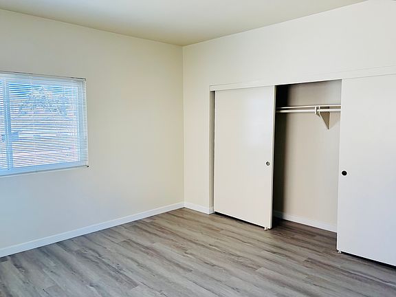 Bedroom with newly-installed light gray laminate flooring.