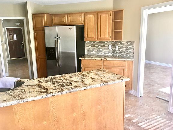 Kitchen area with granite countertops and beautiful tile backsplash