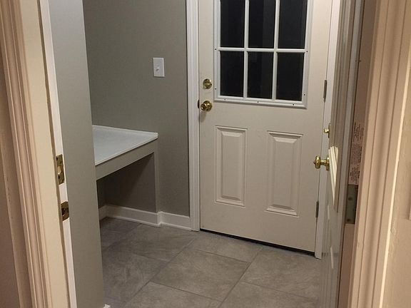 Mud room entry (door closed), stacked washer/dryer to right