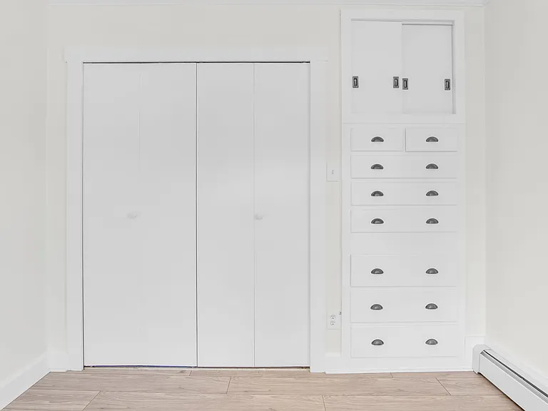 Bedroom - closet system and rack behind doors, built-in dresser