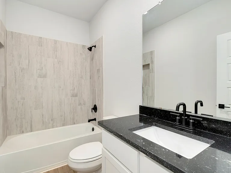 The secondary bathroom has beautiful tile detail.