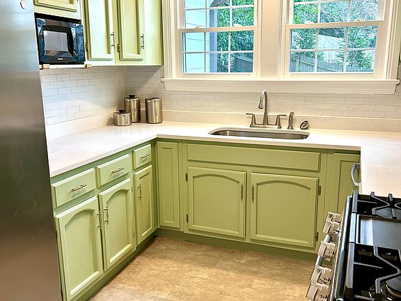 Updated kitchen w new quartz countertops, tile backsplash, new sink and all new appliances (gas stove, dishwasher, fridge, microwave)